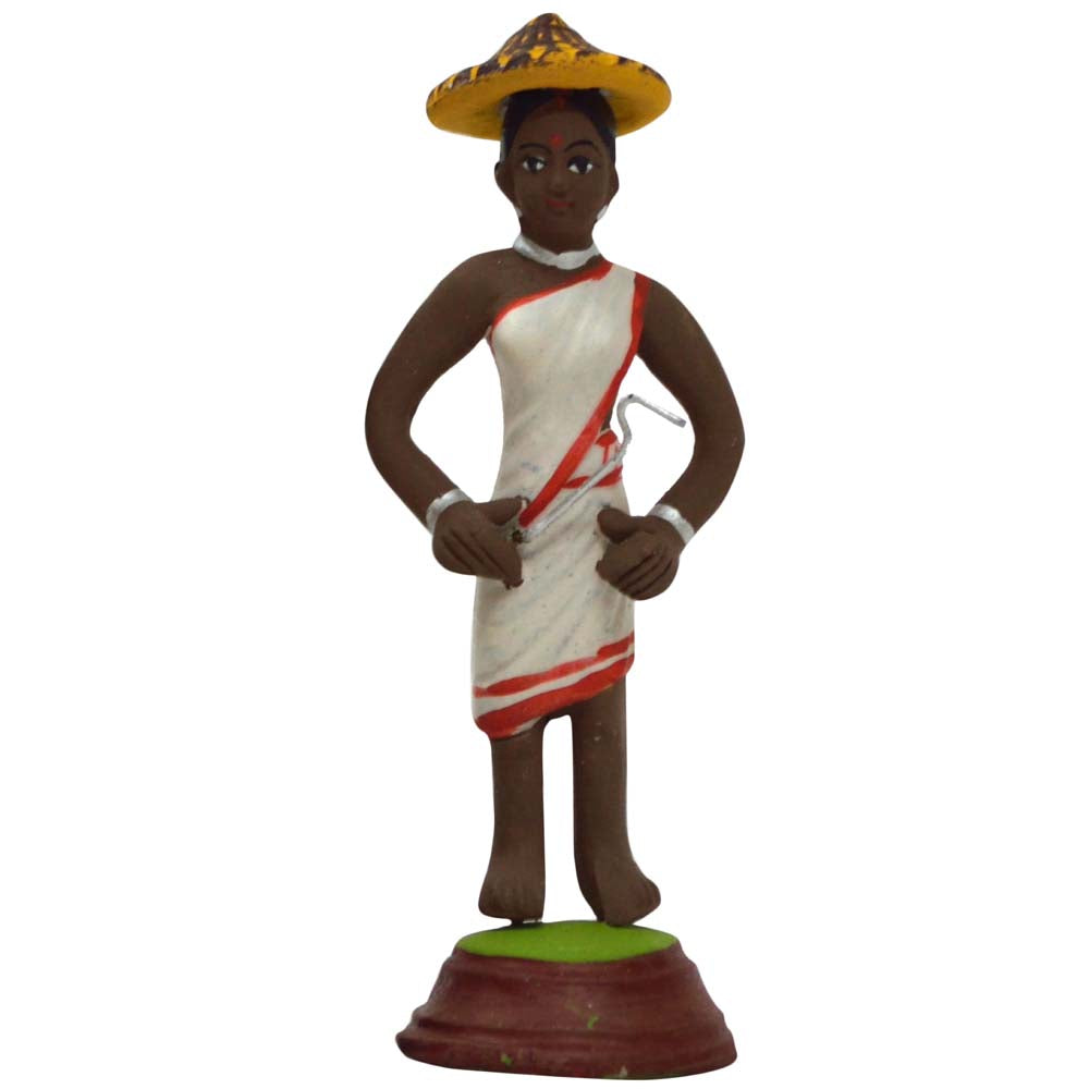 Handcrafted Miniature Tribal Woman Figurine in white attire with red accents, wearing a straw hat and holding a farming tool.