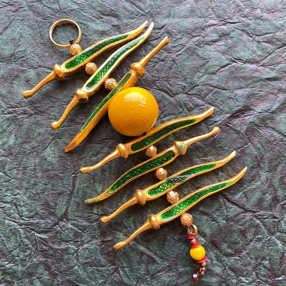 Silvery enamel lemon and chilli gold meena with green chillies and yellow lemon, symbolizing protection and good fortune.