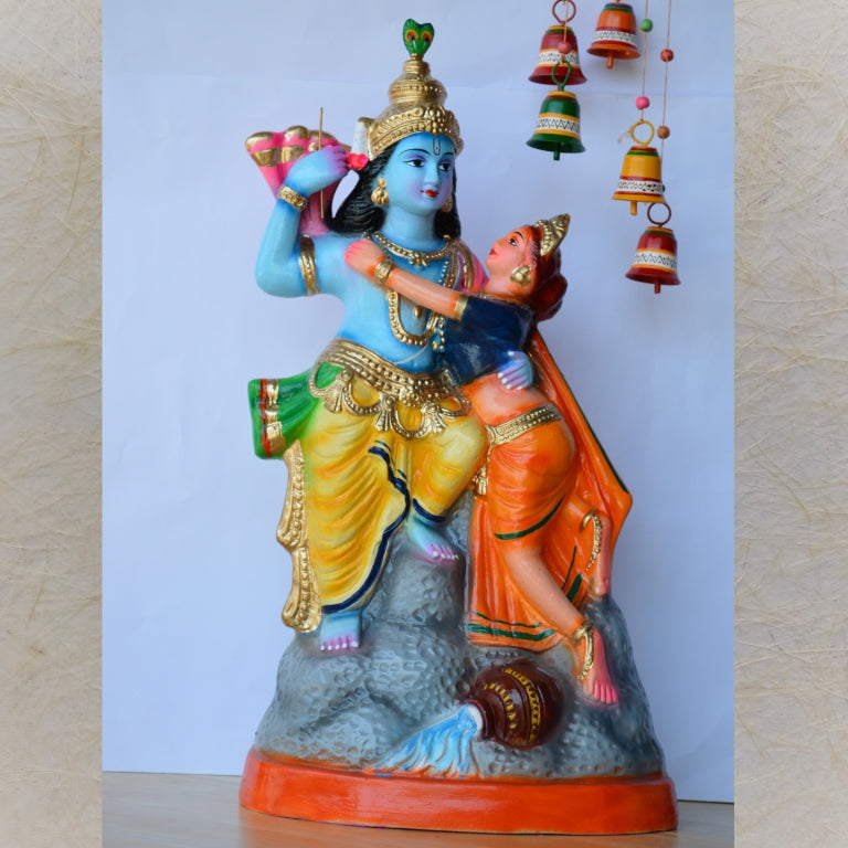 Handcrafted Navarathri Golu doll of Radha and Krishna embracing, adorned with vibrant colors and intricate detailing.