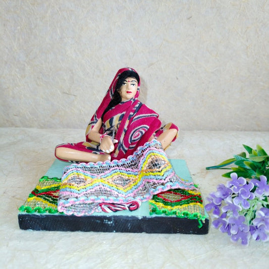 Handcrafted Navarathri Golu doll of a traditional Indian weaver with colorful textile designs and intricate details.