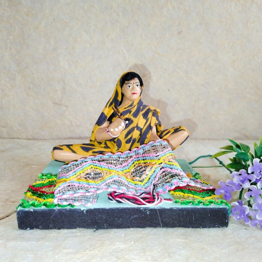 Handcrafted Navarathri Golu doll of a traditional Indian weaver with colorful textile designs and intricate details.