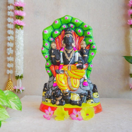 Handcrafted Navarathri Golu doll depicting Lord Dakshinamoorthy seated under a serpent canopy with vibrant detailing.
