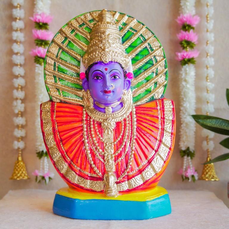 Handcrafted Navarathri Golu doll of Goddess Renugammal with a vibrant gold and green decorative backdrop.