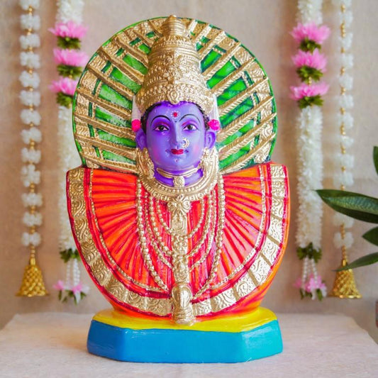 Handcrafted Navarathri Golu doll of Goddess Renugammal with a vibrant gold and green decorative backdrop.