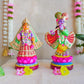 Handcrafted Navarathri Golu Dolls of Mathura Krishna playing flute and Rukmini in traditional attire, adorned with vibrant colors and intricate detailing.