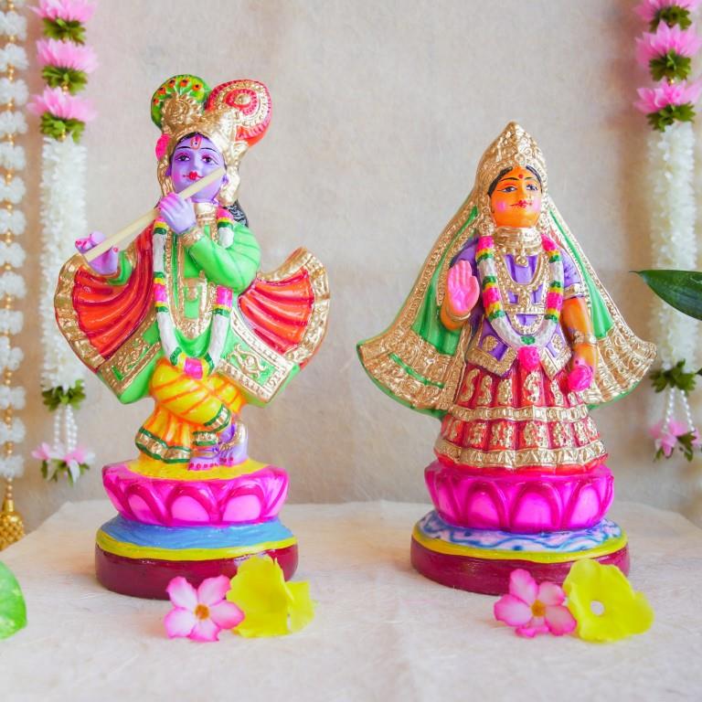 Handcrafted Navarathri Golu Dolls of Mathura Krishna playing flute and Rukmini in traditional attire, adorned with vibrant colors and intricate detailing.