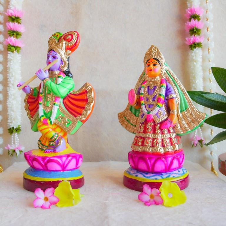Handcrafted Navarathri Golu Dolls of Mathura Krishna playing flute and Rukmini in traditional attire, adorned with vibrant colors and intricate detailing.