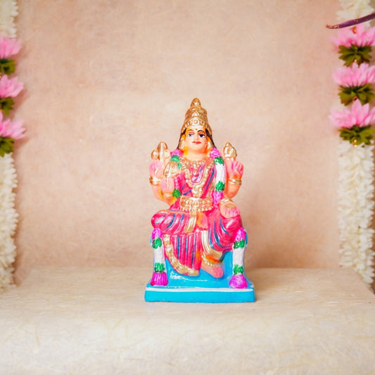 Hand-painted Navarathri Golu doll of Goddess Karumari Amman in a colorful seated posture with intricate detailing and vibrant pink and gold hues.