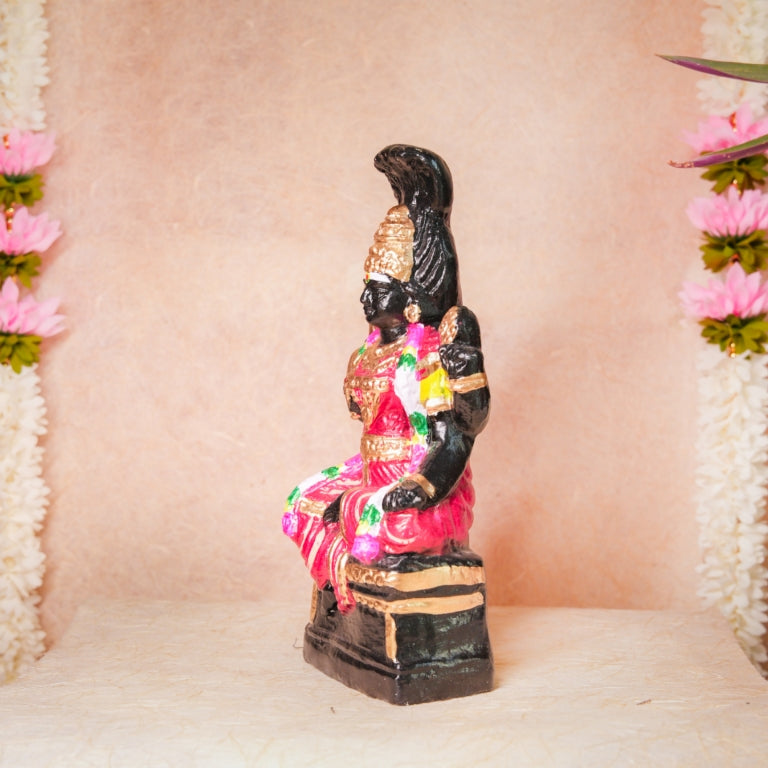 Handcrafted Navarathri Golu doll of Karumari Amman in vibrant pink attire, seated with traditional detailing, adorned with flowers.