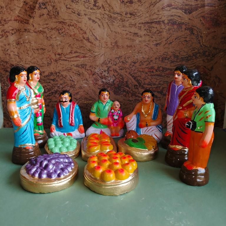 Handcrafted Navaratri Golu doll set featuring a Kadhu Kuthal (Ear Piercing) ceremony with family members, festive food platters, and ceremonial elements.