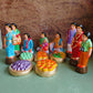 Handcrafted Navaratri Golu doll set featuring a Kadhu Kuthal (Ear Piercing) ceremony with family members, festive food platters, and ceremonial elements.