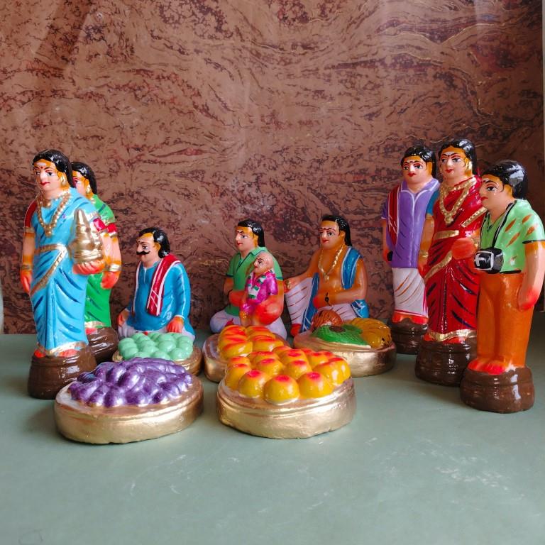 Handcrafted Navaratri Golu doll set featuring a Kadhu Kuthal (Ear Piercing) ceremony with family members, festive food platters, and ceremonial elements.