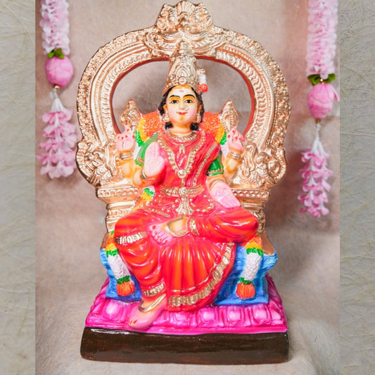 Handcrafted Bhuvaneshwari Amman Golu doll with vibrant colors and intricate throne design, displayed with floral decor.
