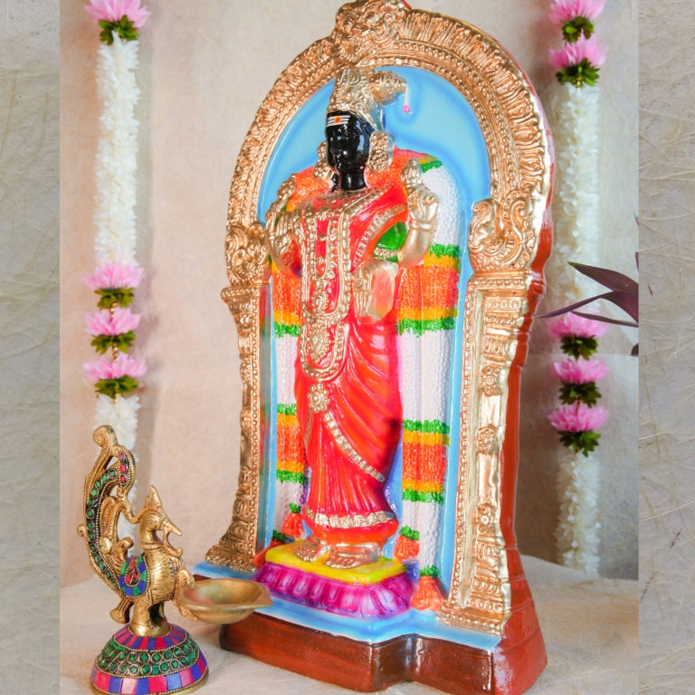 Handcrafted Navarathri Golu doll of Goddess Abirami adorned in a vibrant red saree with intricate jewelry, set within a decorative arch.