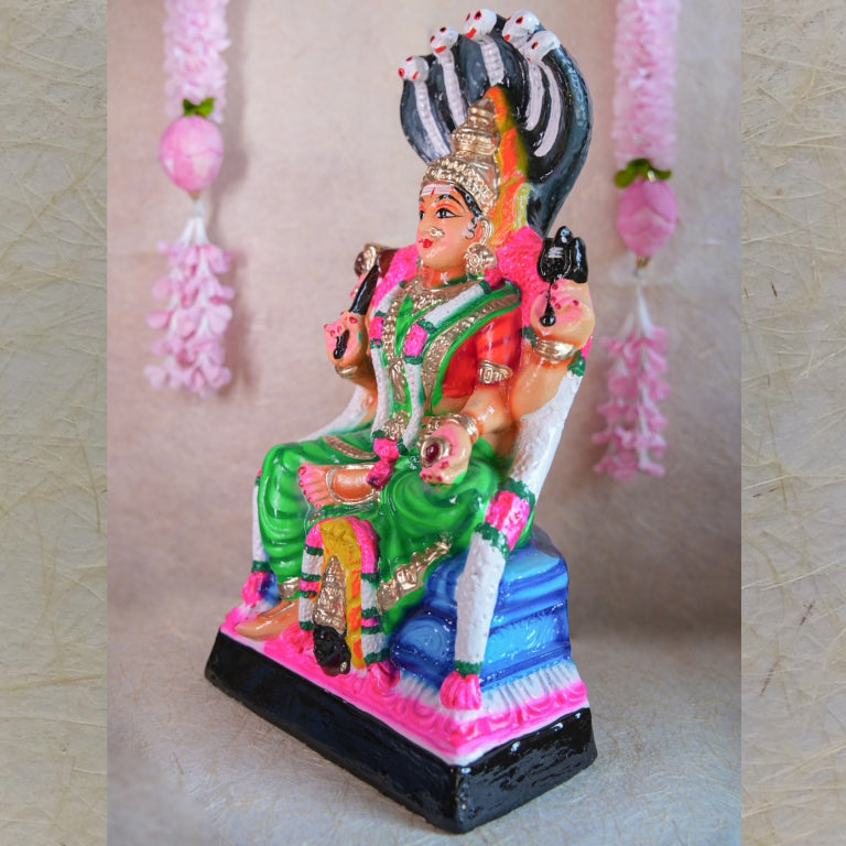 Hand-painted Navarathri Golu Doll of Goddess Karumari Amman seated under a five-headed serpent, symbolizing divine protection and grace.