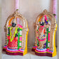 Navarathri Golu Dolls featuring Perumal and Thaayar seated within ornate arches, hand-painted with vibrant traditional colors.