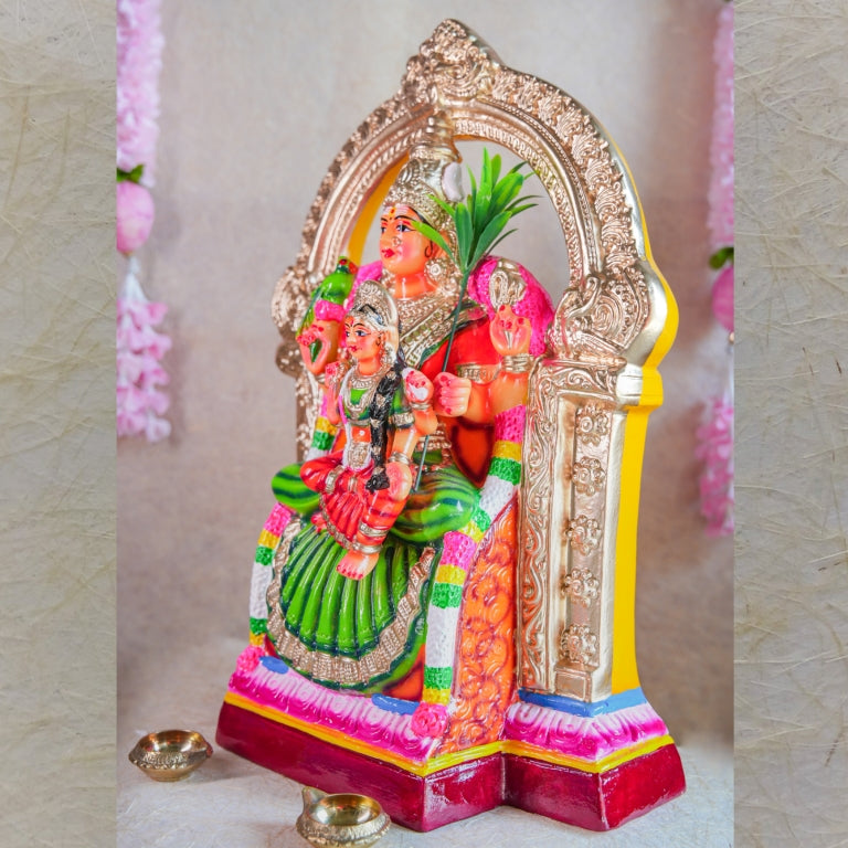 Navarathri Golu Dolls featuring Lalitha Devi holding Tripura Sundari seated within an ornate arch with intricate detailing.