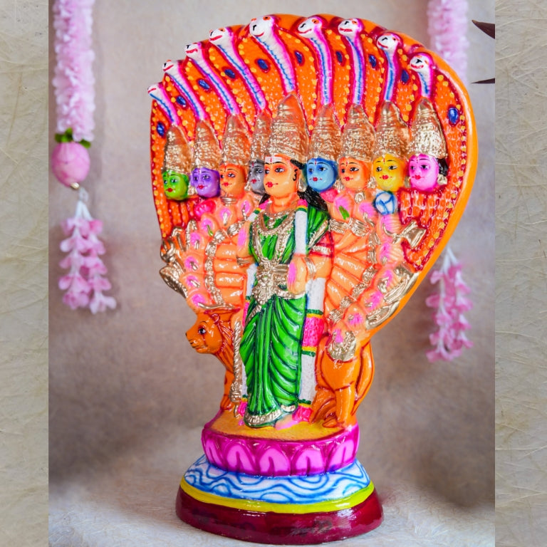 Handcrafted Navarathri Golu Doll of Nava Durga under a serpent canopy, adorned in vibrant colors with a lion mount.