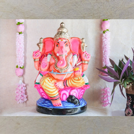 Handcrafted Navarathri Golu Doll of Lord Ganesh in vibrant pink, orange, and gold, seated on a lotus base.