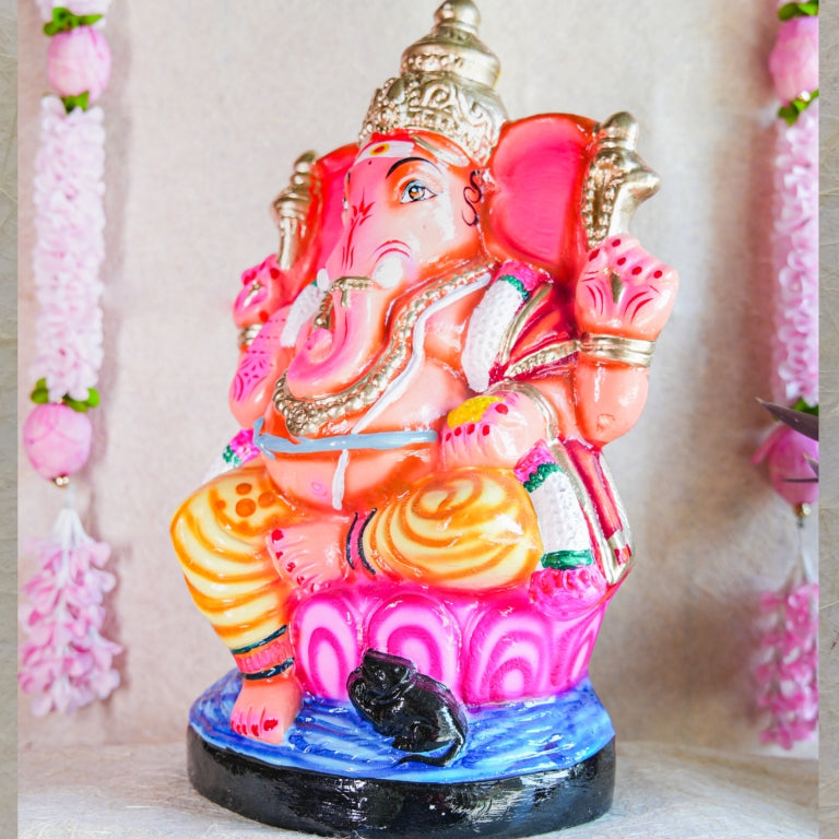 Handcrafted Navarathri Golu Doll of Lord Ganesh in vibrant pink, orange, and gold, seated on a lotus base.