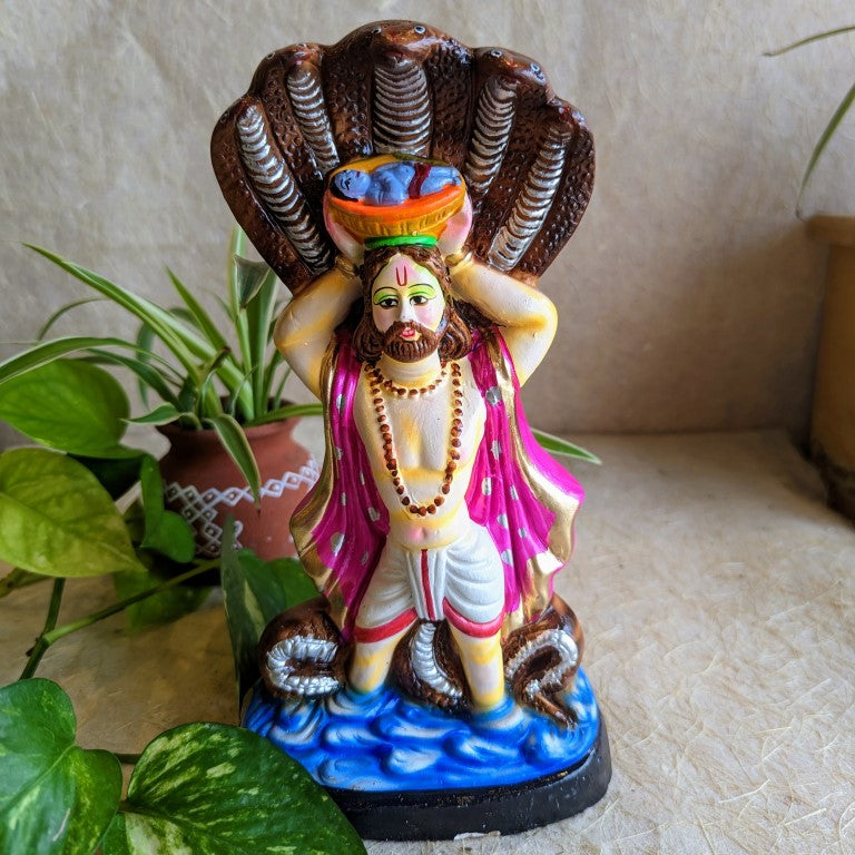 Handcrafted Navarathri Golu doll of Vasudeva carrying baby Krishna in a basket, protected by the serpent Adishesha.