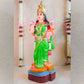 Handcrafted Vasthu Lakshmi idol in a green saree holding pink lotuses, designed for traditional Indian decor and puja purposes.