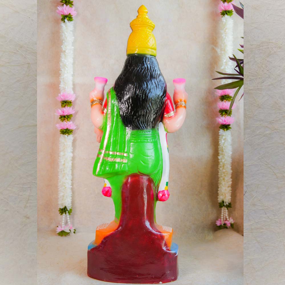 Handcrafted Vasthu Lakshmi idol in a green saree holding pink lotuses, designed for traditional Indian decor and puja purposes.