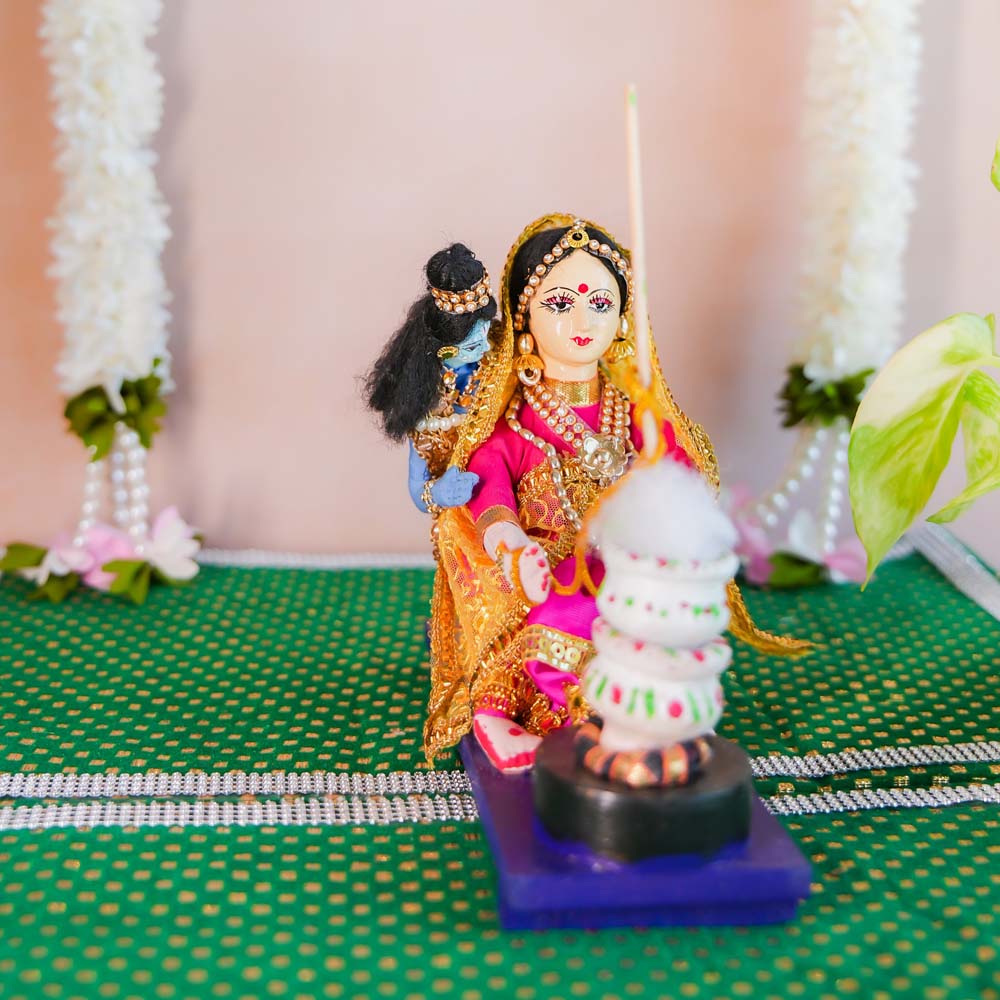 Handcrafted dolls of Yashoda and Gopal churning buttermilk, dressed in vibrant traditional Indian attire, with intricate details and cultural charm.