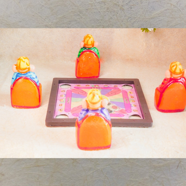 Handcrafted Navarathri Golu doll set of four Ganeshas seated around a carrom board, engaging in a game.