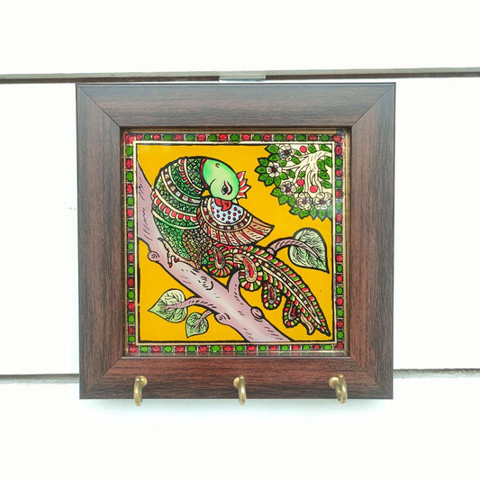 Decorative keyholder featuring a hand-painted parrot design on a vibrant yellow background, framed with dark wood, and fitted with key hooks.