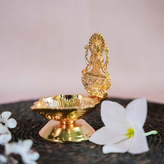 Gold Finish Lakshmi Lamp with Intricate Design of Goddess Lakshmi Seated on a Lotus.