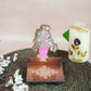 Andal Diya Wall Stand with a colorful depiction of Goddess Andal and a kolam-patterned wooden base for holding oil lamps.