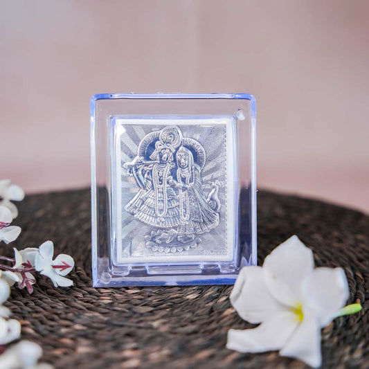 Silver Radha Krishna Frame in a Transparent Stand with Detailed Silver Depiction of Radha and Krishna.