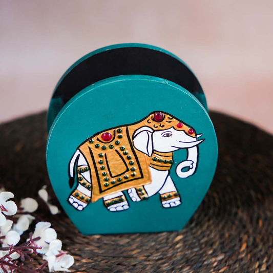 Hand-painted wooden penstand with a decorative elephant design in white and gold on a teal background.