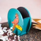 Hand-painted wooden penstand with a vibrant parrot design in peach and gold on a turquoise background.