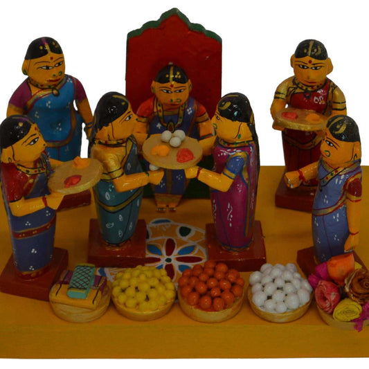 Handcrafted Kondapalli Seemantham Doll Set depicting women in traditional attire celebrating an Indian baby shower with sweets, plates, and decorations.