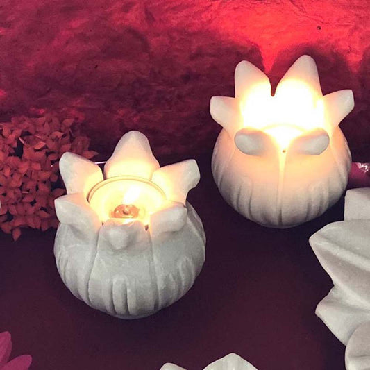 Marble Galaxy Glowing Lotus T-Light Holder in white, glowing warmly with a candle inside, perfect for home decor.
