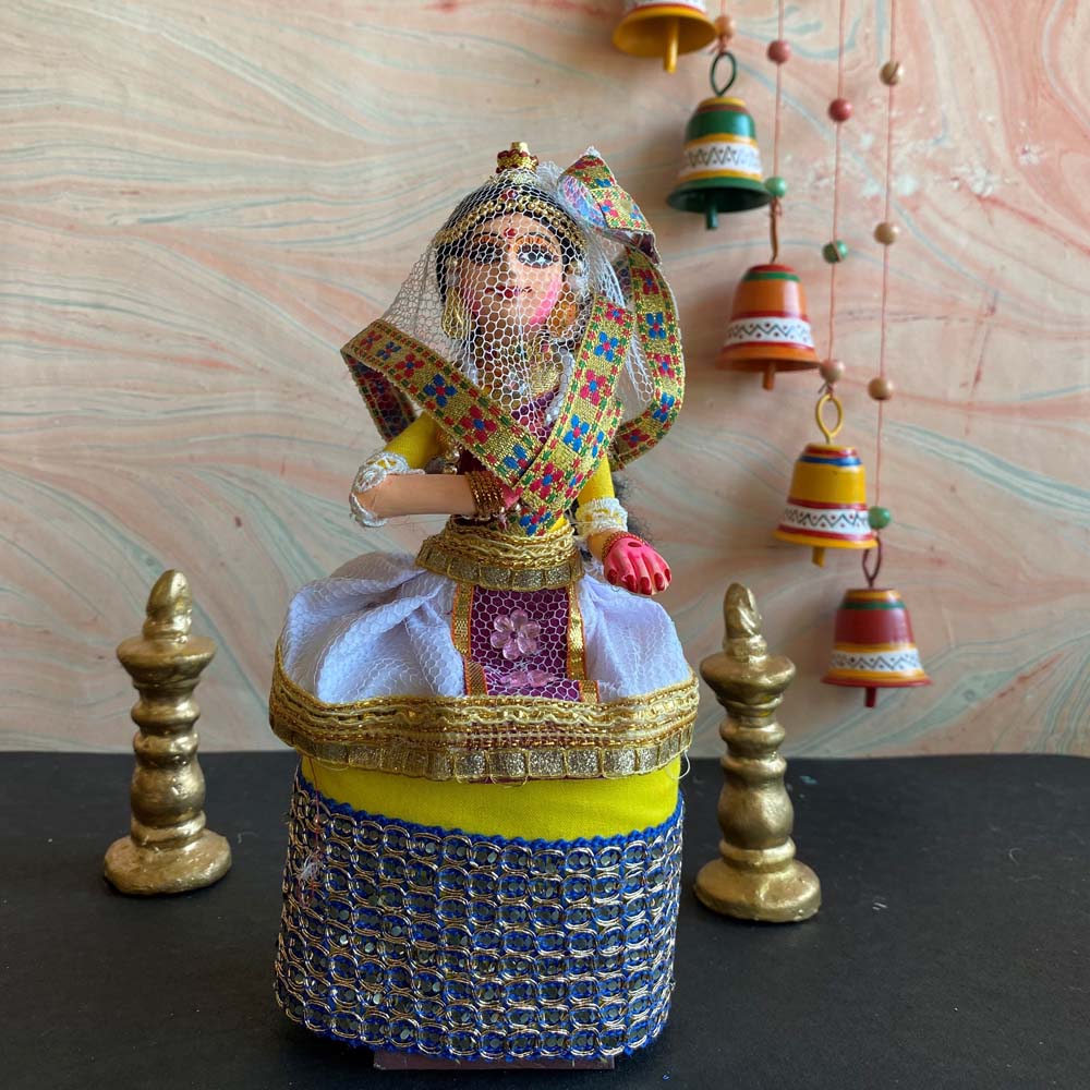 Handcrafted Navaratri Manipuri dancer costume doll in vibrant traditional attire, featuring a headdress and intricate fabric details, standing on a decorative base.