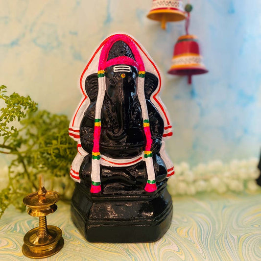 Hand-painted black Pillayarpatti Vinayagar Golu doll adorned with red and white garlands, ideal for Navarathri decoration.