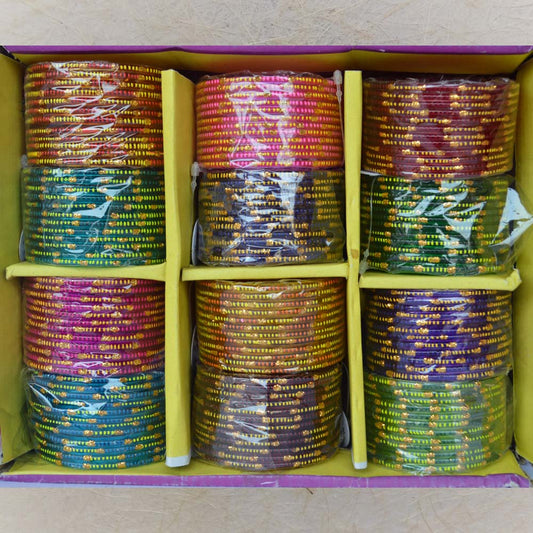 Box of 12 colorful glass bangles with big and small gold dot patterns, ideal for festive occasions, weddings, and traditional wear.