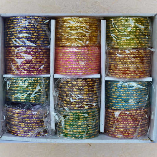 Box of 12 vibrant glass bangles featuring big and small gold dots, perfect for festive occasions, weddings, and traditional attire.