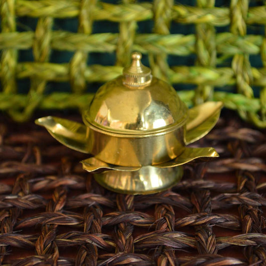 Brass kumkum box designed in the shape of a lotus with a secure lid, ideal for pooja rituals and festive decor.