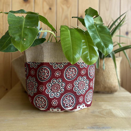 Natural jute plant holder with a vibrant Red Kolam print, designed for indoor plants and eco-friendly decor.