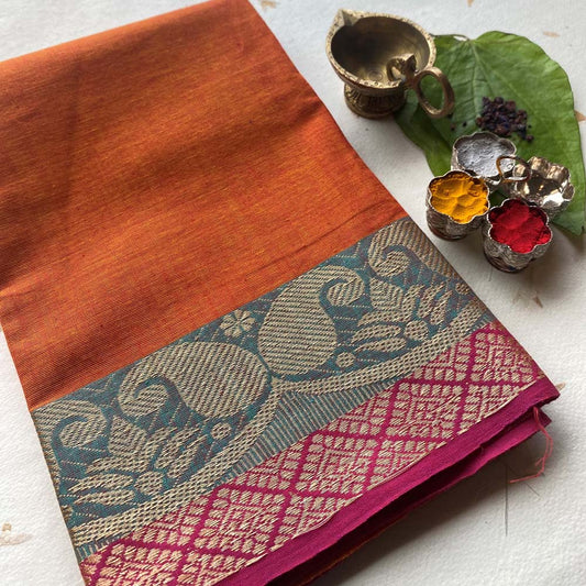 Elegant cotton fabric in orange and yellow with intricate traditional border design, perfect for crafting and festive decorations.