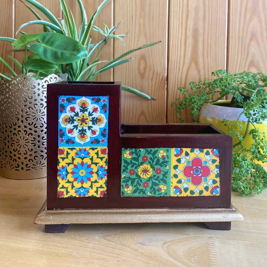 Handcrafted two-partition wooden pen holder adorned with colorful floral ceramic tiles on a desk.