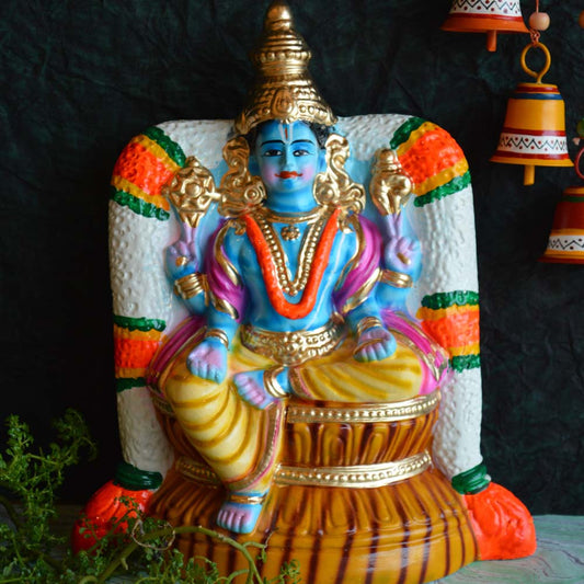 Hand-painted Vishnu Navarathri Golu doll in blue and gold tones, seated under a colorful decorative arch.