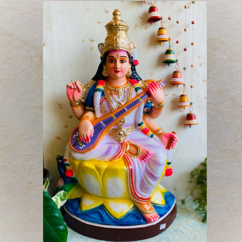 Handcrafted Navarathri Golu Doll depicting Goddess Saraswathi seated on a lotus, holding a veena, painted in vibrant colors with intricate details.