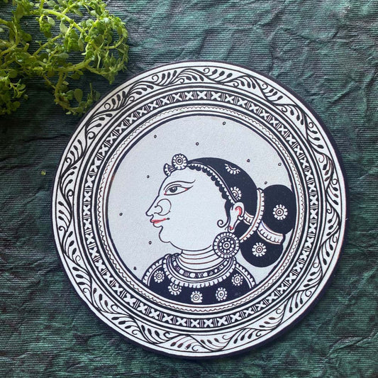 Decorative plate featuring the traditional profile of an Indian lady in grey and black, with intricate detailing, displayed against a green backdrop.