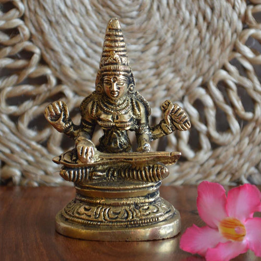 Handcrafted brass Saraswati idol seated with a veena, symbolizing wisdom, learning, and the arts, with intricate detailing.