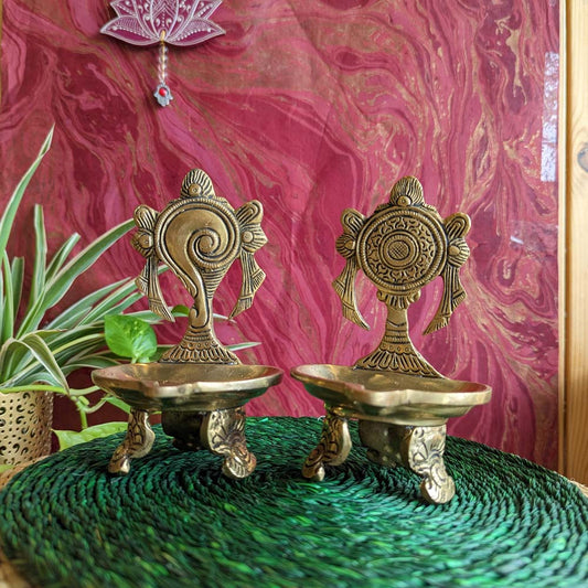 Pair of handcrafted brass Sangu Chakra oil lamps with intricate detailing, perfect for pujas and spiritual decor.